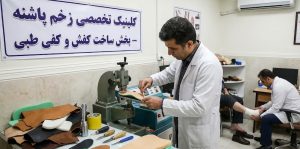 متخصص ارتز و پروتز در حال ساخت کفی طبی مخصوص در کارگاه کلینیک پاشنه برای بیمارانی که دارای نشانه‌های شروع زخم دیابتی هستند.