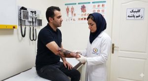 پزشک متخصص در حال معاینه و ارزیابی بالینی برای درمان زخم سوختگی درجه ۳ روی ساعد دست بیمار مرد در کلینیک زخم پاشنه.