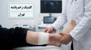 پزشک متخصص در حال معاینه و ارزیابی پای بیمار جهت شروع پروسه درمان زخم عروقی در تهران در کلینیک پاشنه.