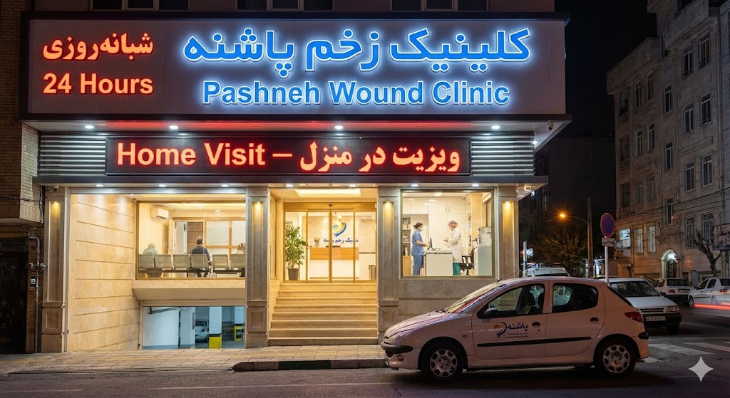 نمای شبانه ساختمان کلینیک زخم پاشنه تهران با تابلوی خدمات شبانهروزی و ویزیت در منزل.
