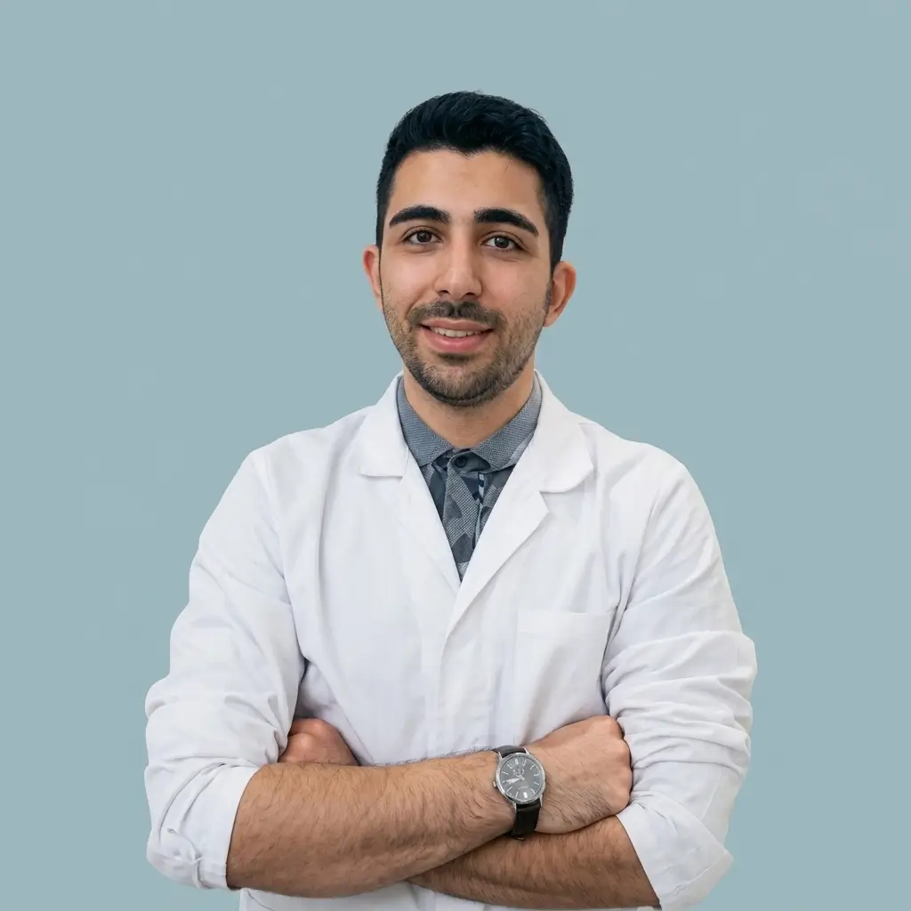 عکس پرسنلی امیرحسین علی آبادی، مدیر اجرایی کلینیک زخم پاشنه با روپوش سفید پزشکی و دست‌های ضربدری.